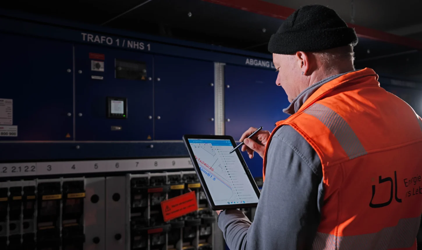 Daniel Spring überprüft Anlagen in einer Trafostation mit einem Tablet